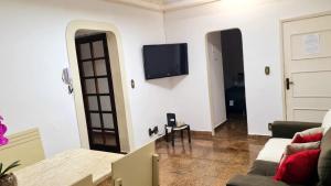 a living room with a couch and a tv on a wall at Praia do Forte Cabo Frio - Apto Beira Mar in Cabo Frio +33 photos