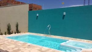 a swimming pool in the side of a building at Recanto Julia in Olímpia