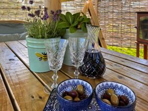 a wooden table with two wine glasses and a vase at Herdwick in Grove