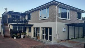 a large house with a balcony and a staircase at Charming Room in Wellingtons Coastal Heart in Wellington