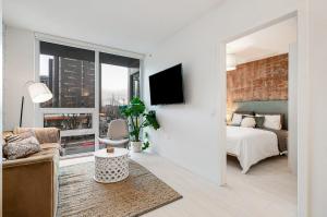 a living room with a bed and a large window at Modern 4-Bed Condo with AC and Parking near SkyTrain for 6 in Vancouver