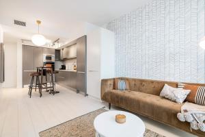 a living room with a couch and a table at Modern 4-Bed Condo with AC and Parking near SkyTrain for 6 in Vancouver