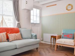 a living room with a couch and a chair at The Wee Cottage in Polperro