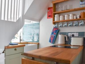 a kitchen with a wooden counter top and a sink at The Wee Cottage in Polperro