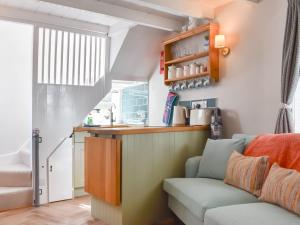 a living room with a couch and a kitchen at The Wee Cottage in Polperro