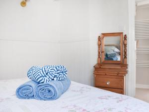 a bed with blue towels on it with a mirror at The Wee Cottage in Polperro +16 photos