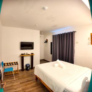 a bedroom with a bed and a chair and a tv at El Puerto Boracay Shore in Boracay