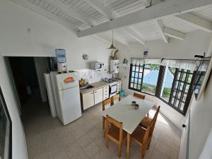 a kitchen with a table and a white refrigerator at La Grutas Casa de Mar in Las Grutas