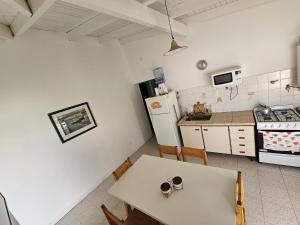 a small kitchen with a table and a refrigerator at La Grutas Casa de Mar in Las Grutas +15 photos