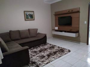 a living room with a couch and a flat screen tv at Recanto Julia in Olímpia