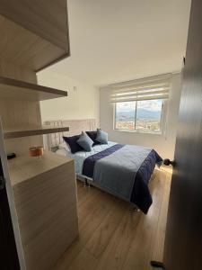 a bedroom with a bed and a large window at Confort 203 Apartamento Duitama in Duitama +10 photos