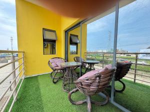 Un balcón con sillas y una mesa en un edificio amarillo. en Adebisi, en Lekki