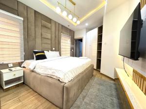 Un dormitorio con una cama grande y un televisor de pantalla plana. en Adebisi, en Lekki 12 fotos más