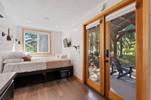 a bedroom with a bed and a sliding glass door at Eco Friendly Tiny Container Home Retreat in Camas