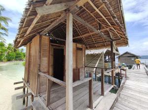 a small wooden building on a pier next to the water at Homestay Yenbeyar Raja Ampat in Yariffi