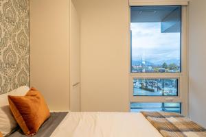 a bedroom with a bed and a large window at Eco-Friendly Condo with AC Gym and Parking near SkyTrain for 5 in Vancouver