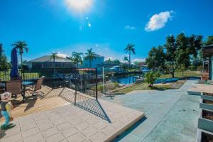 Una vista de un parque infantil con piscina y palmeras. en House With A Boat - Boat, Heated Pool, Fishing, en Cabo Coral