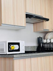 a microwave oven on a counter in a kitchen at Minimalist Comfort Modern Stay Cozy Vibes in Iloilo City