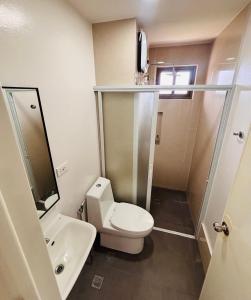 a small bathroom with a toilet and a sink at Minimalist Comfort Modern Stay Cozy Vibes in Iloilo City +4 photos