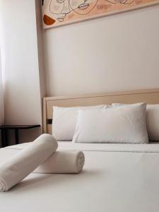 a bed with white sheets and pillows on it at Minimalist Comfort Modern Stay Cozy Vibes in Iloilo City