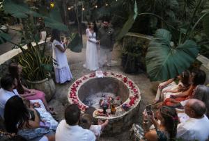 a bride and groom standing in front of a wedding ceremony at ANAND Ecoaldea in Puerto Morelos +54 photos