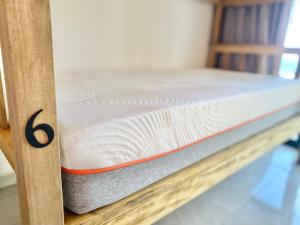 a wooden bunk bed with the number six on it at Sunzal Surf Garden - El Tunco in Tamanique
