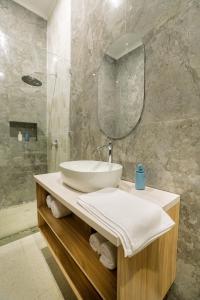 a bathroom with a sink and a mirror at The Villing in Cemagi