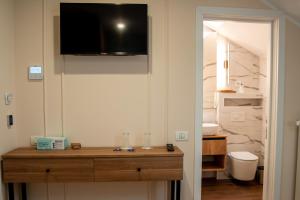 a bathroom with a toilet and a television on the wall at Volotel SkyWay in Cluj-Napoca +174 photos