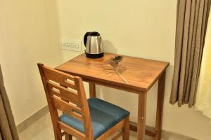 un tavolo di legno con una sedia e un frullatore sopra di Nila Heavens - Spacious 5 BHK Homestay , ideal for families a Guruvayoor
