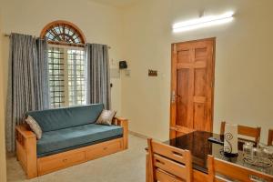 un soggiorno con divano blu e porta in legno di Nila Heavens - Spacious 5 BHK Homestay , ideal for families a Guruvayoor