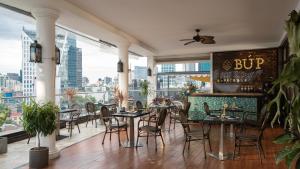 a restaurant with tables and chairs and a big window at The Odys Boutique Hotel in Ho Chi Minh City