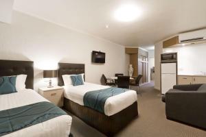 沃加沃加Pavilion Hotel Wagga Wagga的一间有两张床和一间客厅的酒店房间 更多37张照片