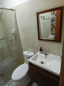 a bathroom with a toilet and a sink and a mirror at Hotel Los Jacintos in Buga +27 photos