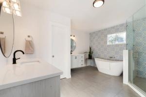 a white bathroom with a tub and a sink at Luxury Bungalow Near Main W Hot-tub And Firepit in Fredericksburg +30 photos