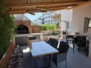 a patio with a table and chairs and a fireplace at Calypso - newly equiped, with separate entrance and parking in Supetar