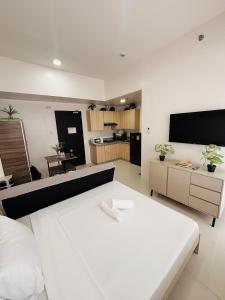 a living room with a white couch and a kitchen at WV 11 Light & Fresh Studio in Iloilo City