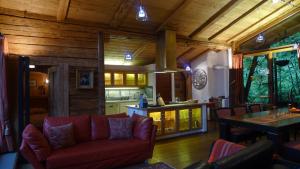 salon z czerwoną kanapą i kuchnią w obiekcie Luxus Chalet Mühlermoos w mieście Ramsau im Zillertal +37 zdjęć