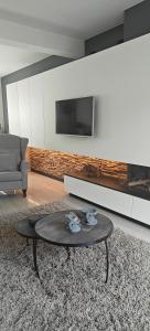 a living room with a coffee table and a tv at holiday home Zonnestraal in Zonhoven