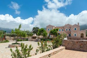 a large stone building with a fountain in a courtyard at Pandora in Pyrgos Dirou