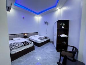 a bedroom with two beds and a blue ceiling at Nhà Nghỉ Tân Tiến in Hà Lộc