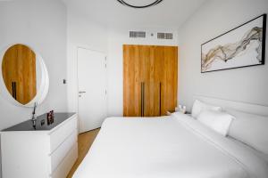 アブダビにあるCanal View 1BR near Galleria Mall & Clevelandの白いベッドルーム(大型ベッド1台、木製のドア付) +22枚の写真