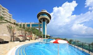een zwembad met een parasol naast een toren bij H Resort in Checheng