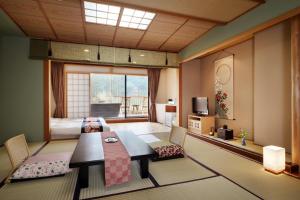 a living room with a table and chairs and a bedroom at Tsuganoki in Nikko