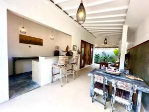 Una cocina y un comedor con mesa y sillas. en Pondok Dembe, en Uluwatu