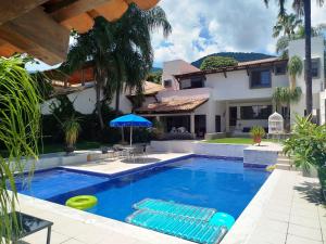 a swimming pool with two lounge chairs and a house at Beautiful Rooms at Villa La Floresta in Ajijic