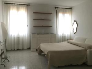 ヴェネツィアにあるSILVIA'S HOMEのベッドルーム1室(ベッド1台、ドレッサー、窓2つ付)