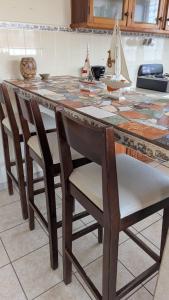 a wooden table with chairs and a table with a model boat on it at Apartamento Coco & Tambor in Livingston Izabal in Lívingston
