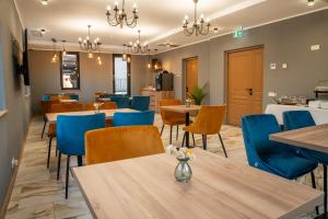 a dining room with tables and blue chairs at Volotel SkyWay in Cluj-Napoca