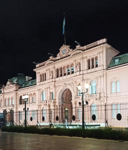 a building with a flag on top of it at night at Palermo Vibes, All in walking distance in Buenos Aires