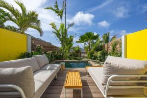 a patio with a couch and a table and a pool at Yellow Hut in Anse des Cayes